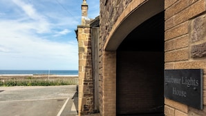A stone building with a sign reading "Harbour Lights House". - Harbour Lights House (Seahouses)