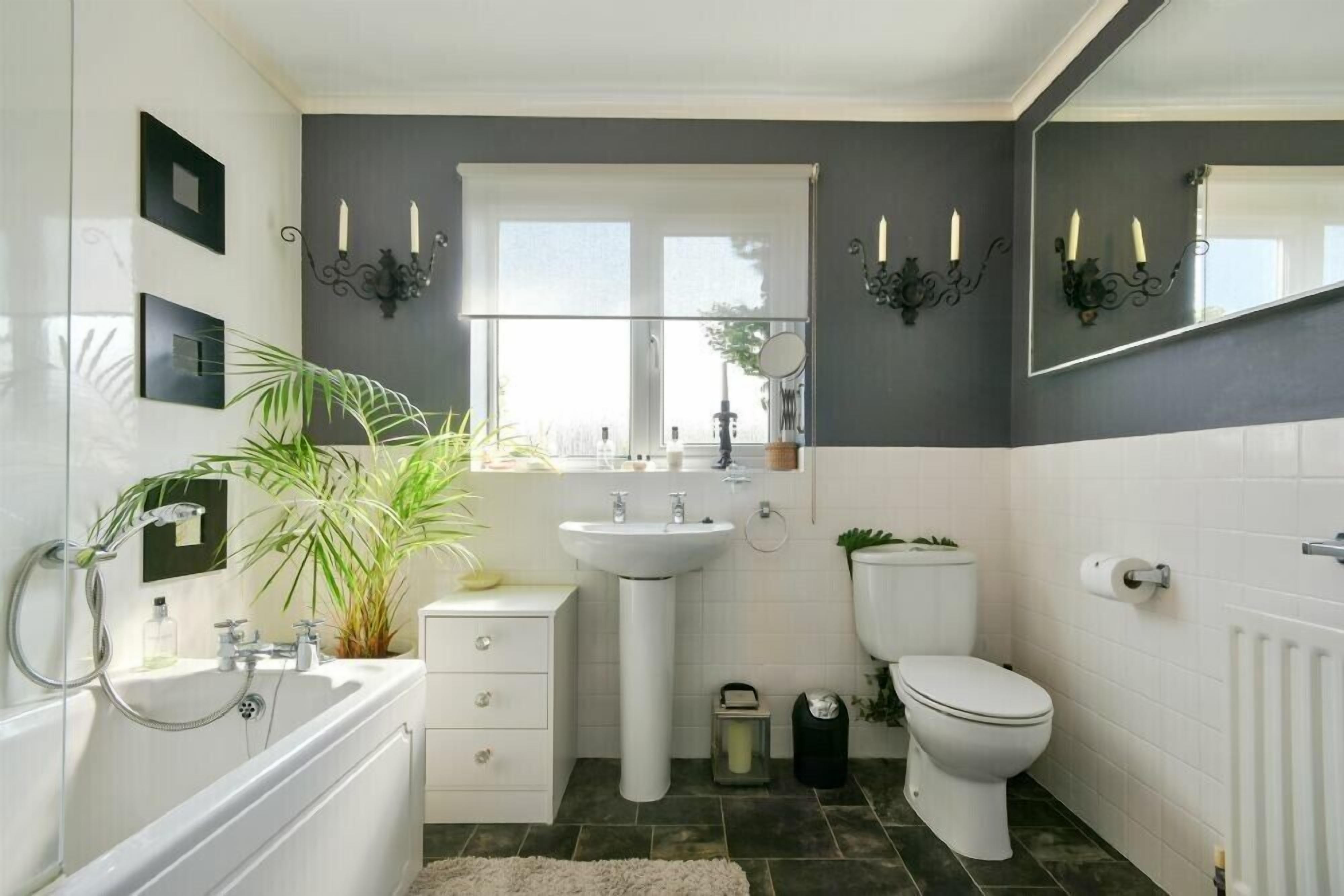 A modern bathroom with a bathtub, sink, and toilet.