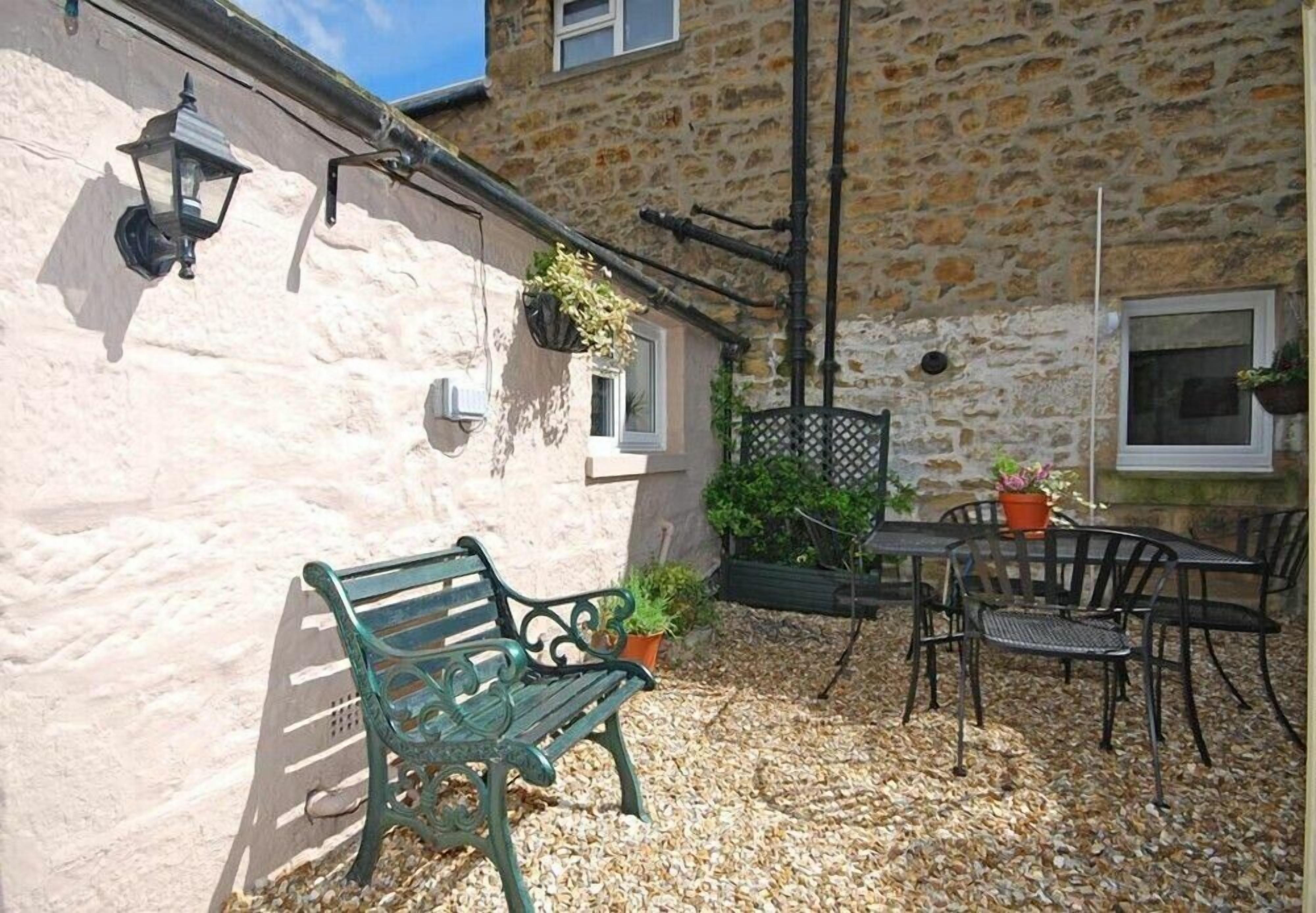 A stone building with a bench and outdoor seating area.
