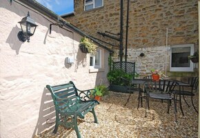 A stone building with a bench and outdoor seating area.