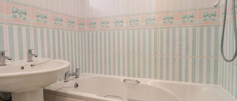 Un baño con bañera, lavamanos y ducha.