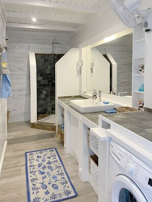 Chuveiro, secador de cabelo, toalhas de banho, papel higiênico