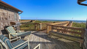 A wooden deck with lounge chairs and a barbecue grill overlooking the beach. - Graves Cottage - 6 Bedroom Oceanfront Cottage w/Walkway to Beach (Southern Shores)