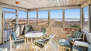 A covered outdoor seating area with a view of the beach. - Graves Cottage - 6 Bedroom Oceanfront Cottage w/Walkway to Beach (Southern Shores)