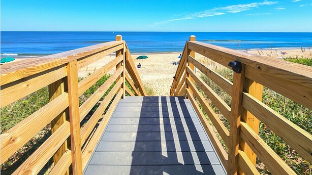 A wooden boardwalk leading to a beach with clear skies. - Just Duck Inn - Bright, Cheerful, 2BR/2BA Semi-Oceanfront condo in Duck, Sleeps 4-7 (Duck)