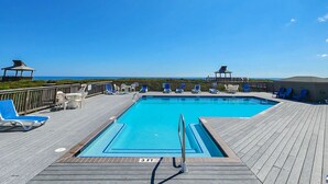 A pool area with a wooden deck, lounge chairs, and a view of the ocean. - Parzanese -  Semi-Oceanfront 1 BR/2BA condo in Duck (Duck)