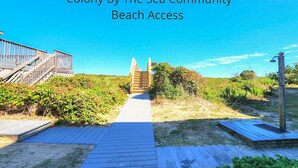 A wooden boardwalk leading to a beach with a wooden staircase and a beach access sign. - Parzanese -  Semi-Oceanfront 1 BR/2BA condo in Duck (Duck)