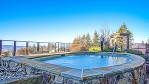A stone pool with a wooden deck, surrounded by a stone wall and a metal fence. - 2 Br Seneca Condo 200 Beautiful Vista Views (Snowshoe)
