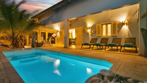 A swimming pool with lounge chairs and a patio area.
