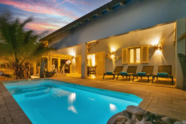 A swimming pool with lounge chairs and a patio area.