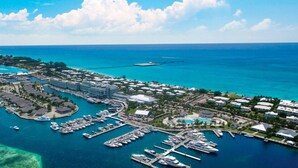 Eine Luftaufnahme eines Küstenresorts mit einer Marina, mehreren Gebäuden und klarem, blauem Wasser.