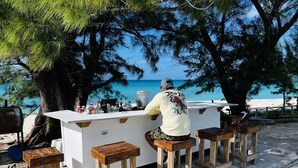 Eine Bar mit Bartender, einer weißen Theke und Holzstühlen.