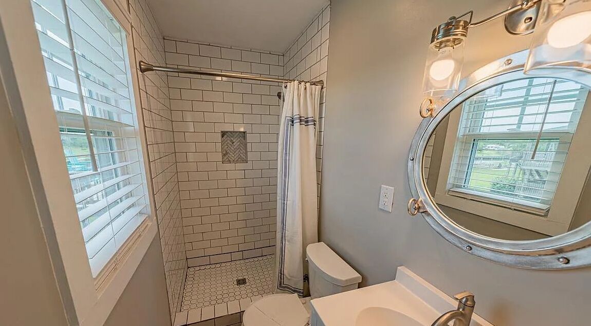A bathroom with a shower, toilet, and sink.