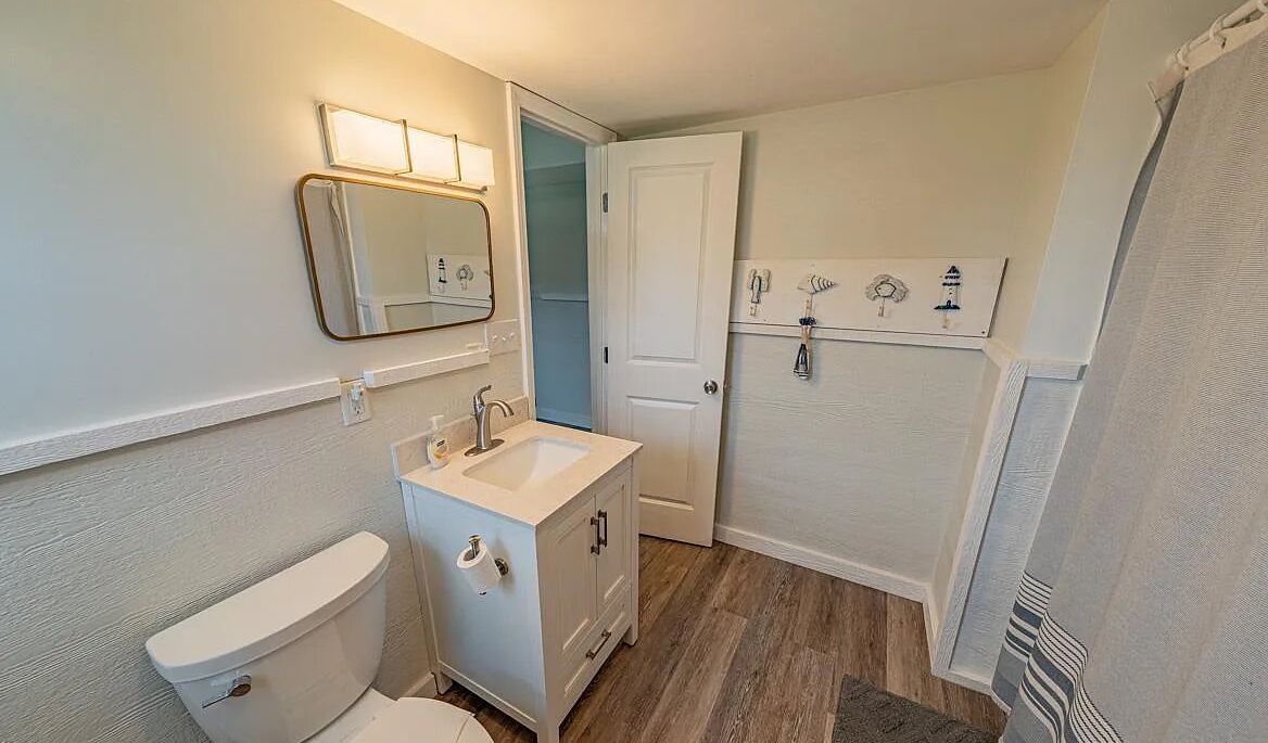 A compact bathroom with a toilet, sink, and shower area.