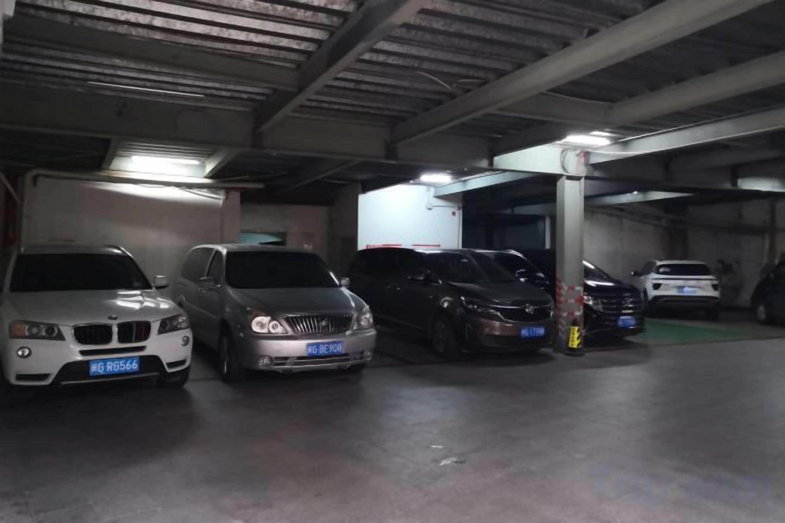 Un aparcamiento con varios coches estacionados en filas.