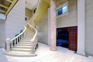 Una imponente escalera con piso de mármol que conduce a un nivel superior.
