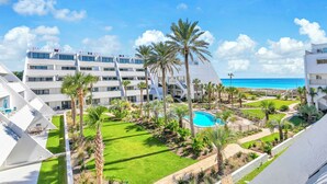 Et moderne hotel med flere etager, en swimmingpool og havudsigt.