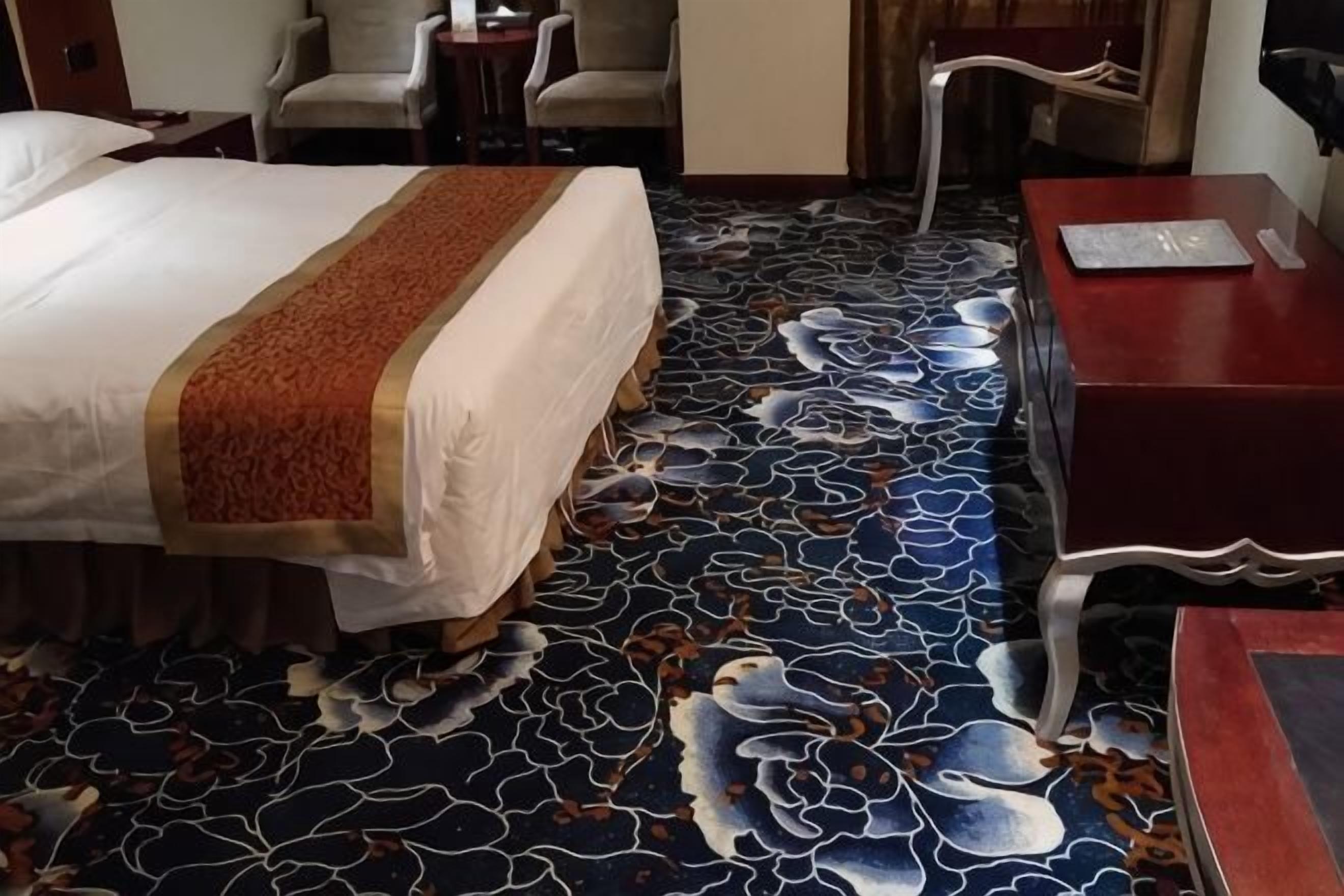 A hotel room with a bed, a desk, and a chair.