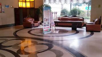A lobby with a circular patterned floor, a reception desk, and seating areas.