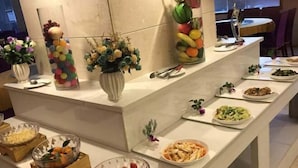 A buffet setup with various dishes and decorative elements. - Qianhao Hotel (Tongzi County)