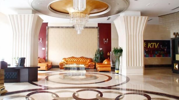 A lobby with a central seating area, a reception desk, and a chandelier. - Qianhao Hotel (Tongzi County)