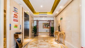 A hotel lobby with a marble floor, a reception desk, and a painting on the wall. - Vienna International Hotel ( Shunde Jun'anBiguiyuan Golf Club） (Foshan)