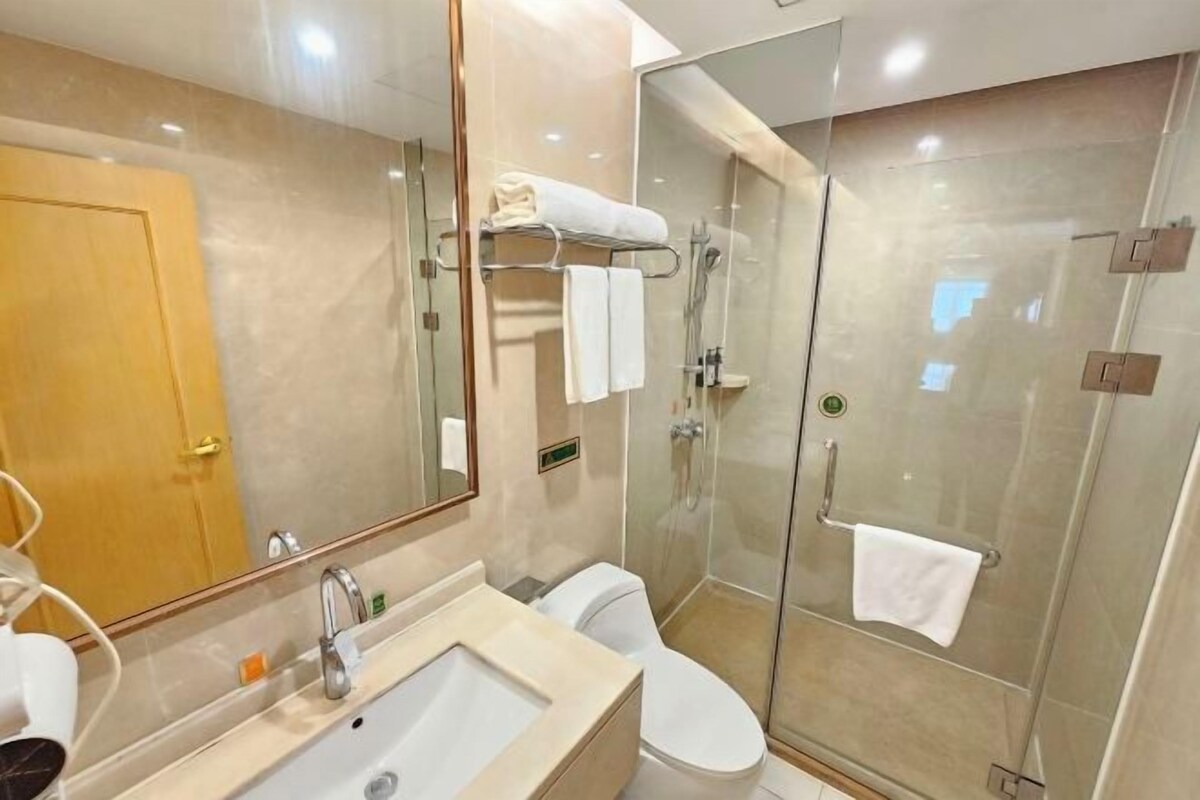 A modern bathroom with a glass-enclosed shower, a sink, and a toilet.