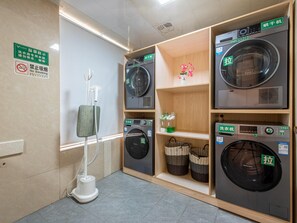 A laundry facility with multiple washing machines, a no-smoking sign, and a floor heater. - Vienna International Hotel ( Shunde Jun'anBiguiyuan Golf Club） (Foshan)