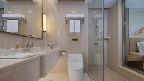 A modern bathroom with a glass shower enclosure, a toilet, and a sink with a mirror. - Vienna International Hotel ( Shunde Jun'anBiguiyuan Golf Club） (Foshan)