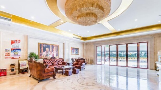A spacious lobby with a large chandelier, leather sofas, and a polished floor. - Vienna International Hotel ( Shunde Jun'anBiguiyuan Golf Club） (Foshan)