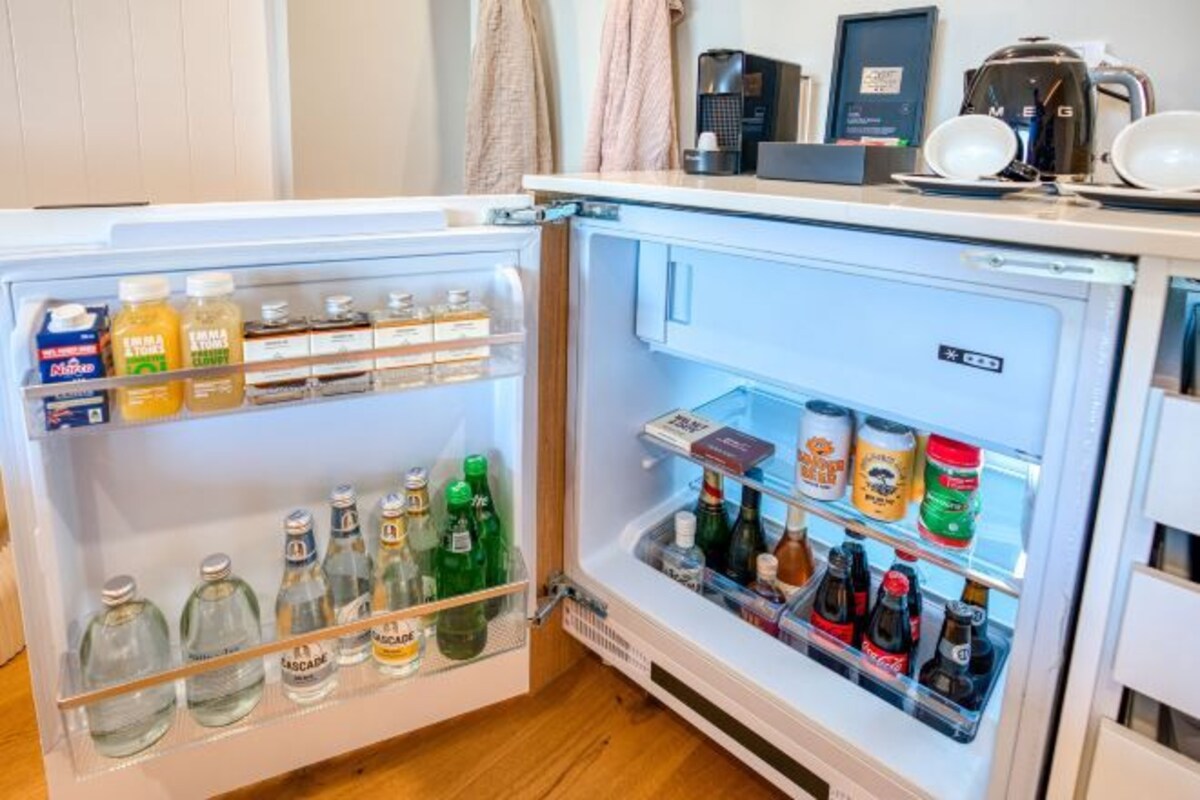 Un refrigerador lleno de bebidas y condimentos.