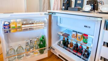 An open refrigerator stocked with beverages and food items.