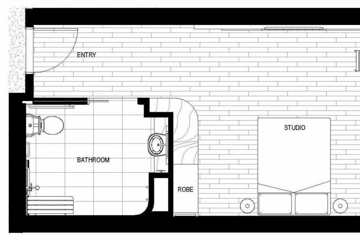 Plano de planta que muestra una entrada, estudio, balcón, baño y bata.