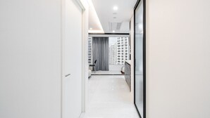 Un couloir moderne et bien éclairé, offrant une vue sur le paysage urbain à travers une grande fenêtre.