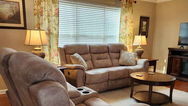 A living room with a sofa, a recliner, a coffee table, and a television. - Discover Maryville and the Great Smoky Mountains (Maryville)