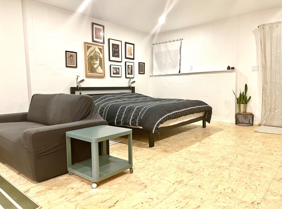 Una camera da letto con un letto, una poltrona, un tavolino e una pianta in vaso.