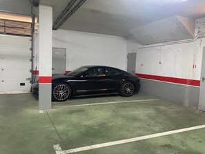 Un parking où une voiture noire est garée dans un espace réservé à cet effet.