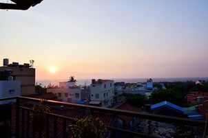 Vista del atardecer desde un balcón con vistas a una zona residencial, edificios y cielo despejado.