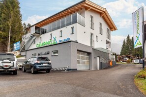 A modern building with a 'CAMPING' sign, a 'FERIENWANNUNGEN RESTAURANT' sign, and a 'Dr. Laut' sign.