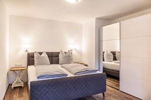 Une chambre à coucher moderne avec un grand lit, des tables de chevet et une armoire.
