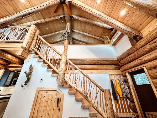 Una scala in legno con ringhiera, che conduce a un piano superiore.