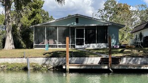 A house with a screened porch overlooking a body of water. - Spring 12% Discount-April May: The Hidden Jim River Cottage -4 Kayaks (Spring Hill)