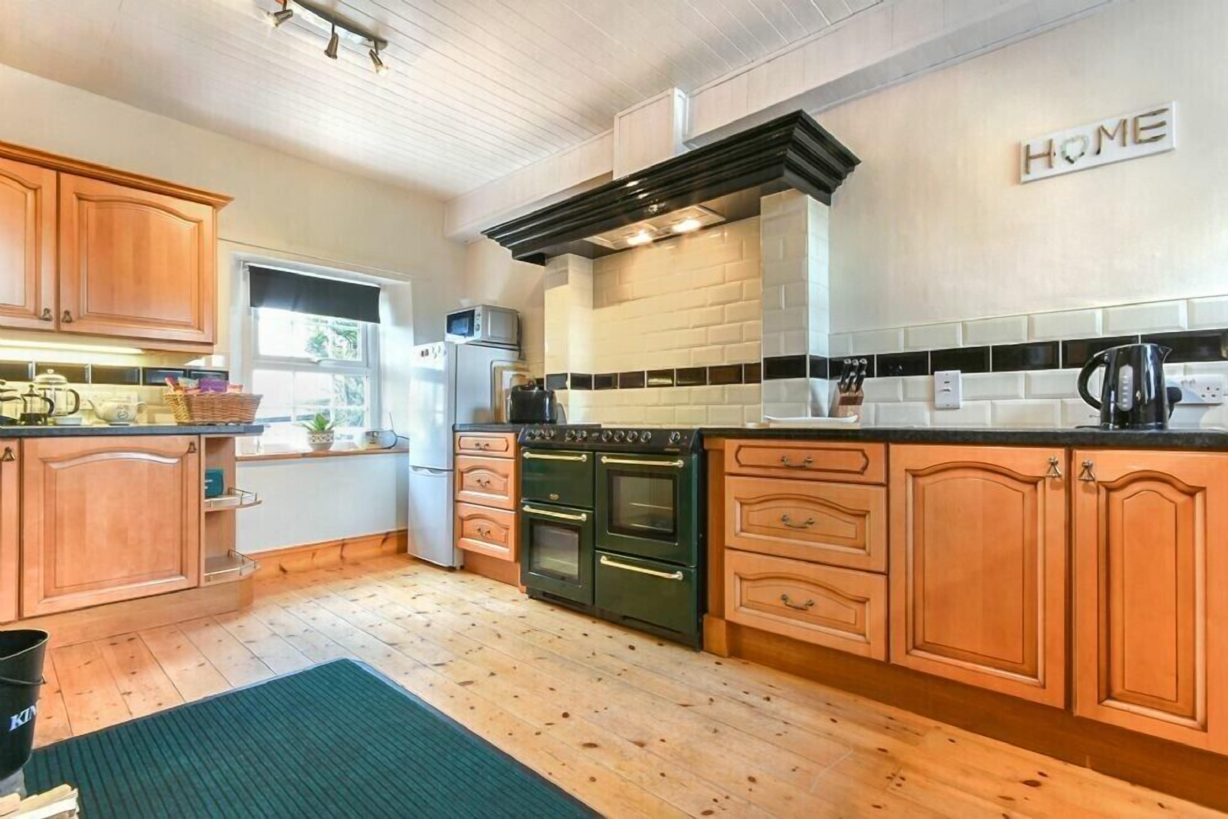 A kitchen with wooden cabinets, a black stove, and a microwave.