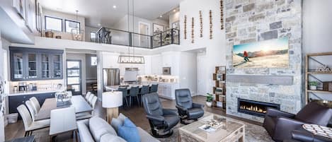 A spacious living area with a fireplace, a dining area, and a kitchen.