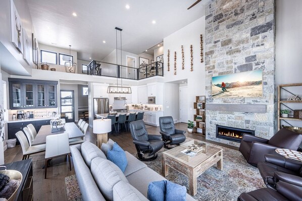 A spacious living area with a fireplace, a dining area, and a kitchen.