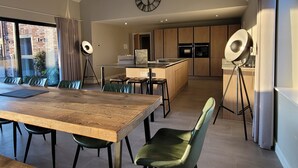 Una cocina moderna con armarios de madera, una isla central y un reloj en la pared.