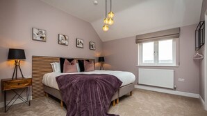Ein Schlafzimmer mit einem Bett, Nachttischen, einem Fenster mit Jalousien und einem Wandbild.