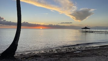 Na praia, espreguiçadeiras, toalhas de praia 