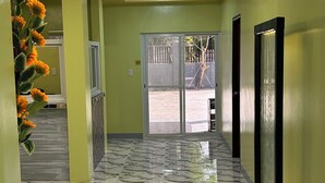 A hallway with a marble floor, a chandelier, and a large mirror on the wall. - Scarlett Resorts at Laganas  (Bugallon)