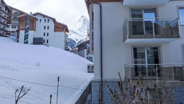 A modern building with a balcony, a snowy landscape, and a mountain in the background. - Grillon by Interhome (Zermatt)